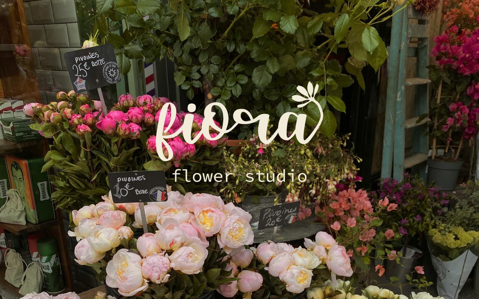 A crowded and cluttered flower market display with various buckets of flowers.