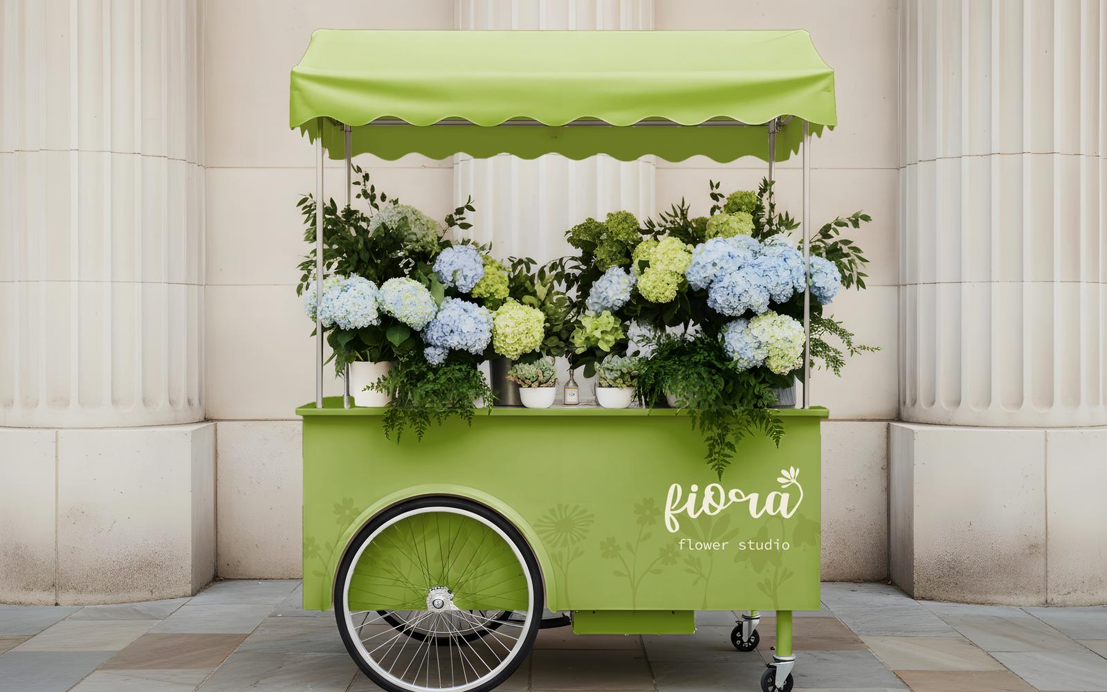A lime green branded mobile flower cart with bicycle wheels and a striped awning parked before white columns.