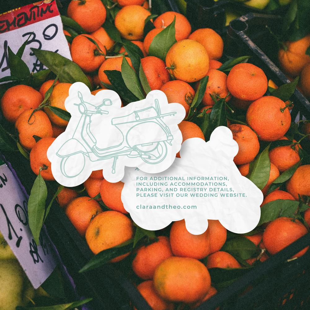 Close-up of orange-themed wedding stationery pieces mixed with fresh fruit textures.